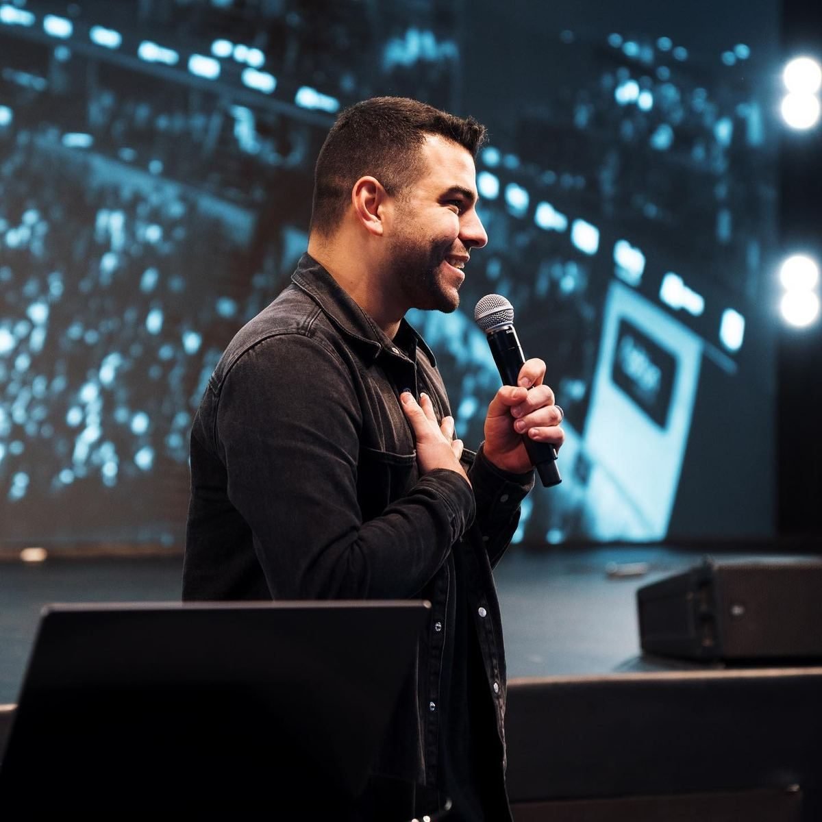 Léo Neves speaking into a microphone on stage