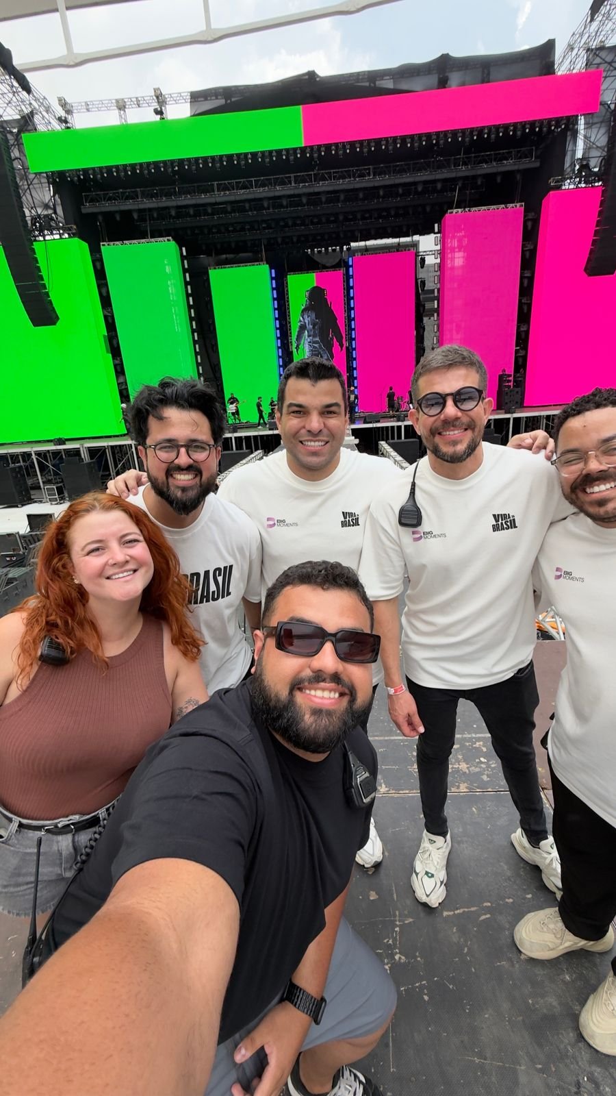 The crew in Big Moments and Vira Brasil shirts in front of the stage
